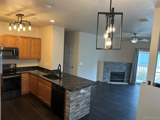 a kitchen with granite countertop a stove top oven and chandelier