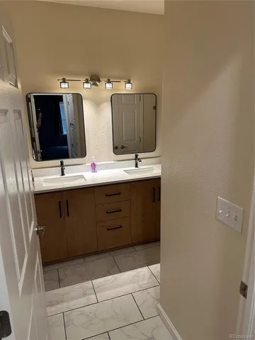 a bathroom with a double vanity sink and mirror