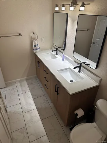 a bathroom with a double vanity sink and mirror