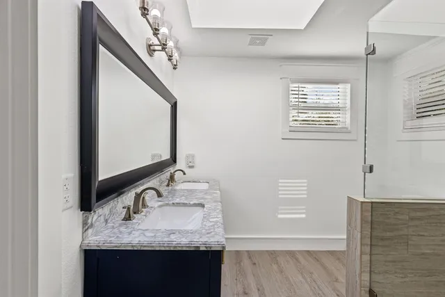 a bathroom with a granite countertop sink and a mirror