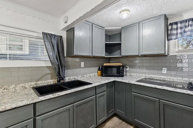 a kitchen with stainless steel appliances granite countertop a sink and white cabinets