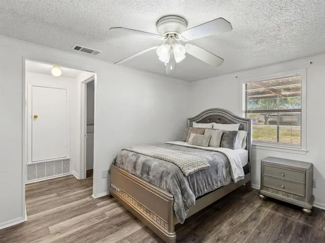 a bedroom with a bed and wooden floor