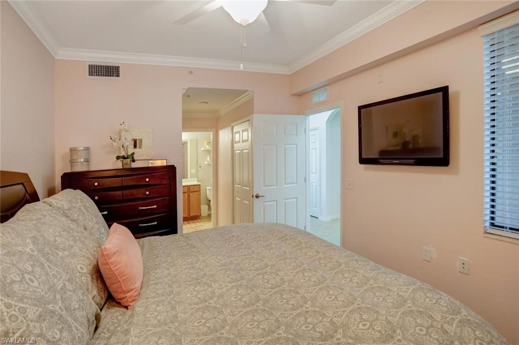 9731 Acqua Court, Unit 523 Naples, FL 34113 - Photo 12 of 27 a bedroom with a bed and a flat screen tv