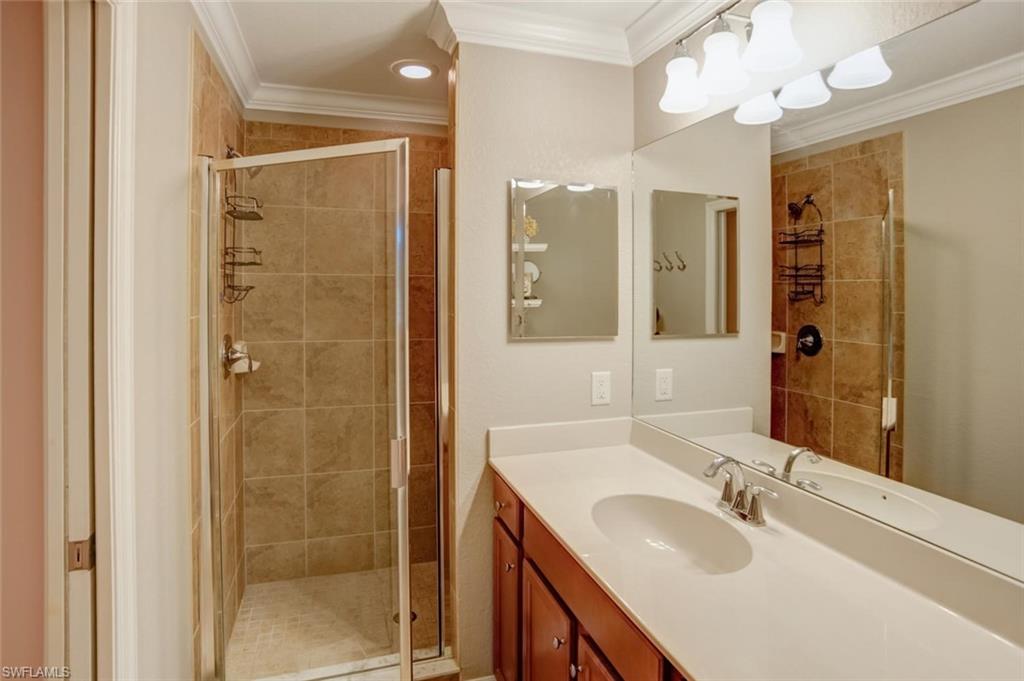9731 Acqua Court, Unit 523 Naples, FL 34113 - Photo 13 of 27 a bathroom with a shower sink vanity granite and mirror