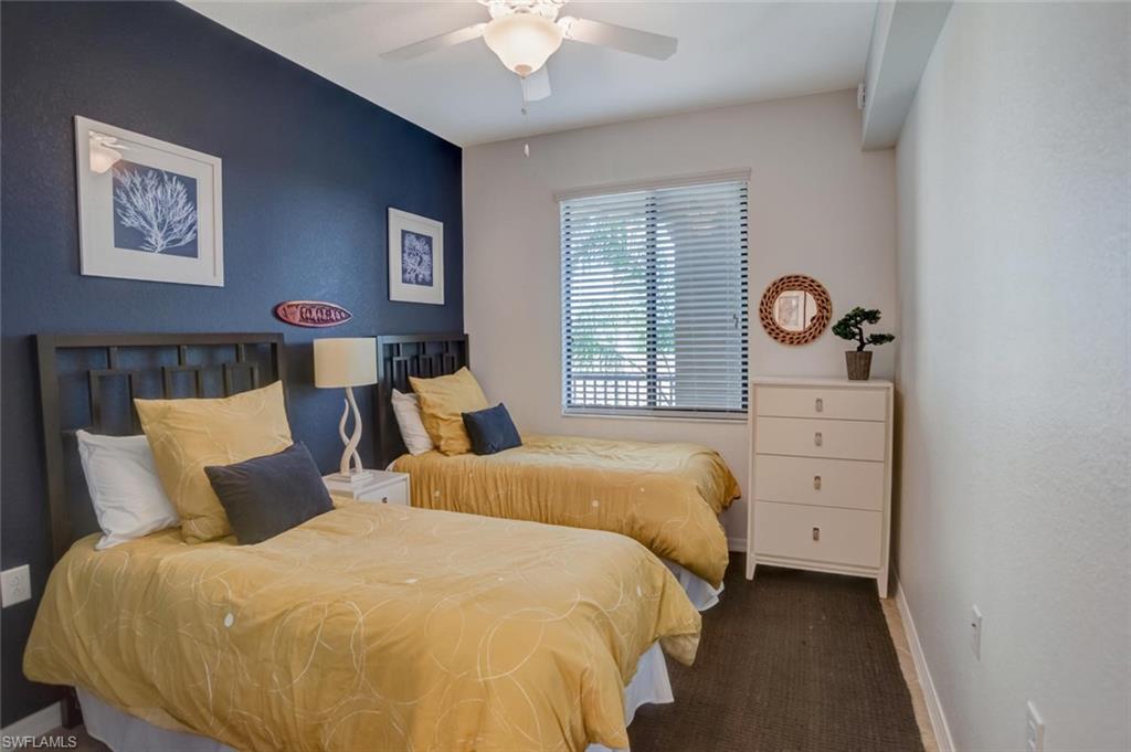 9731 Acqua Court, Unit 523 Naples, FL 34113 - Photo 15 of 27 a bed room with a bed and a lamp