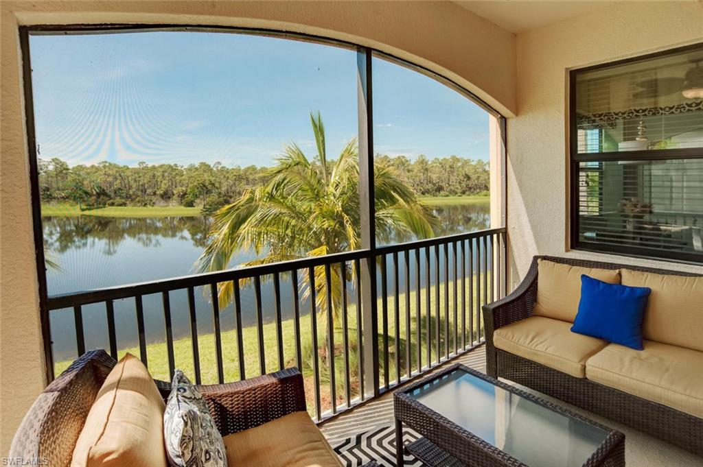 9731 Acqua Court, Unit 523 Naples, FL 34113 - Photo 18 of 27 a balcony with table and chairs