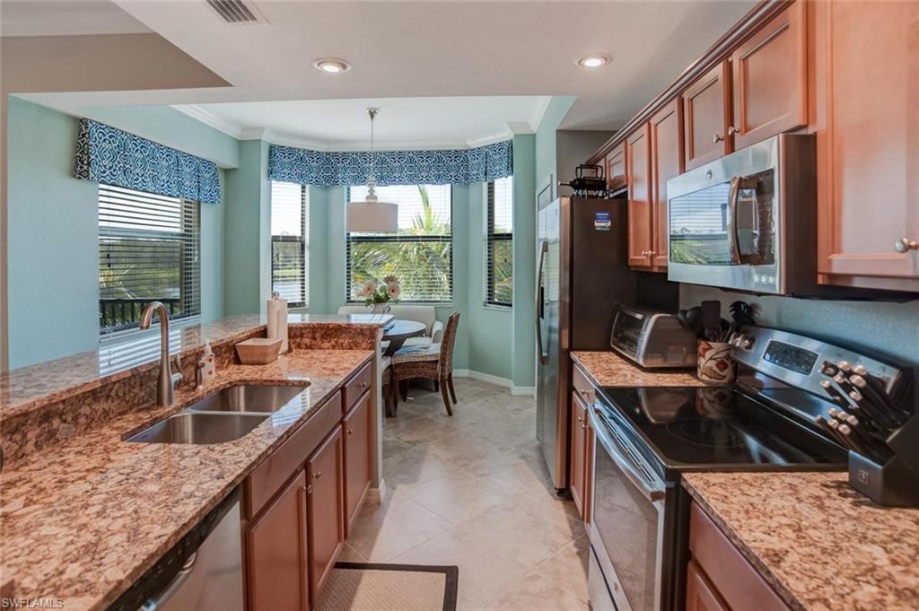 9731 Acqua Court, Unit 523 Naples, FL 34113 - Photo 6 of 27 a kitchen with sink stove and cabinets