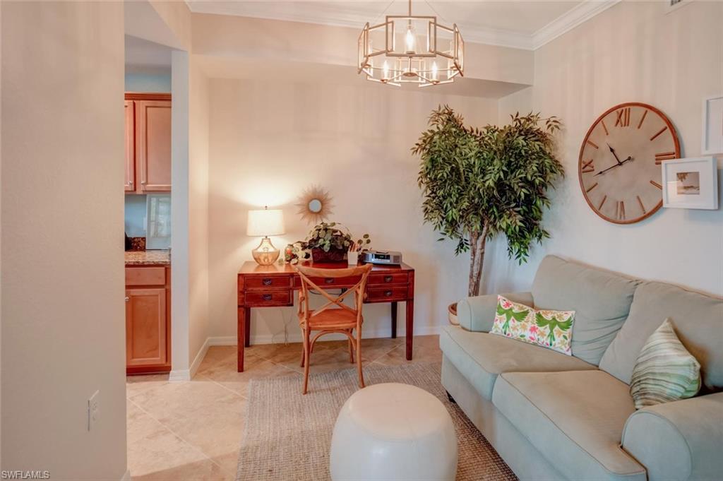 9731 Acqua Court, Unit 523 Naples, FL 34113 - Photo 9 of 27 a living room with furniture a chandelier and a dining table