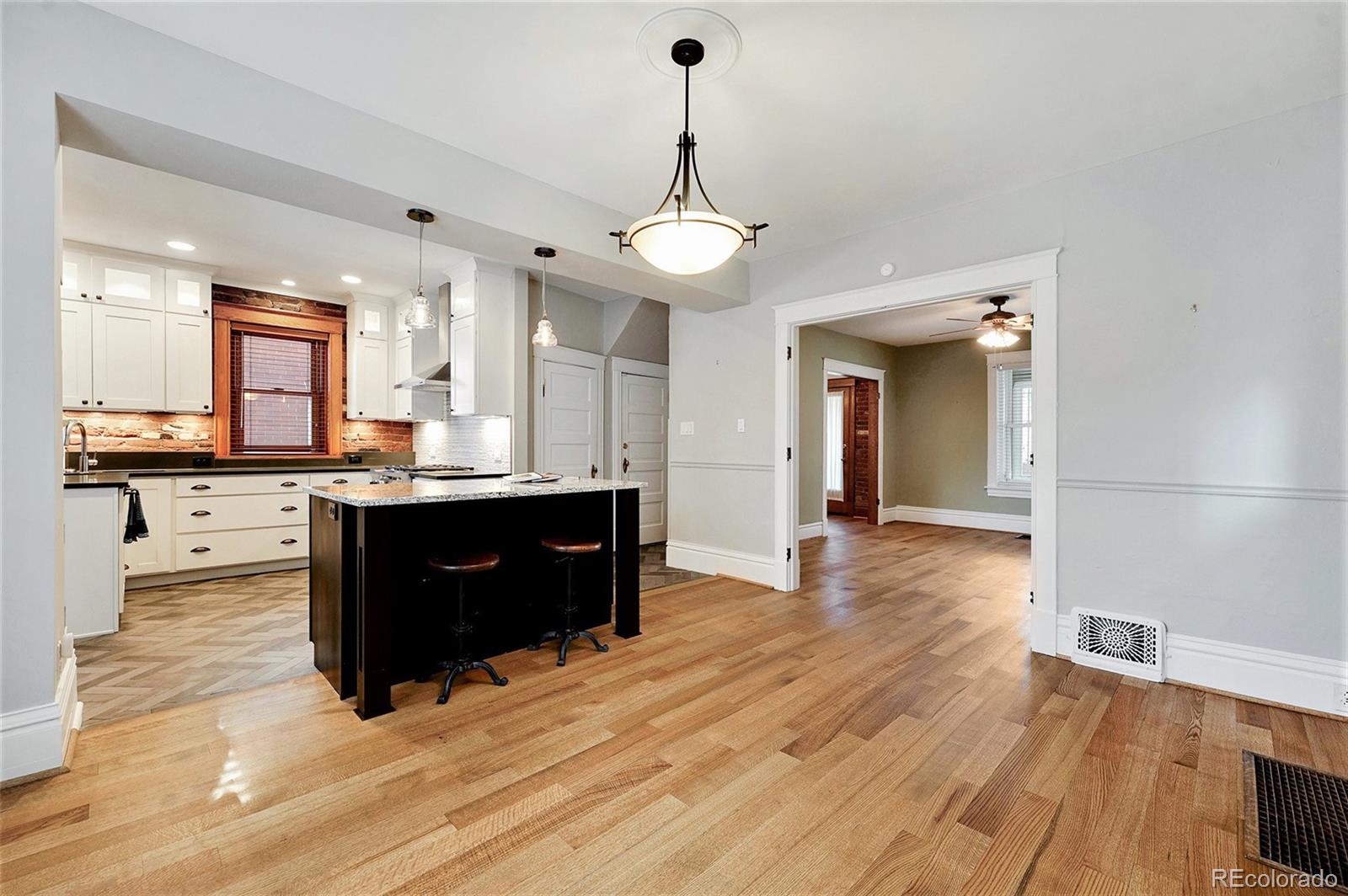 1419 Adams Street Denver, CO 80206 - Photo 11 of 34 a kitchen with stainless steel appliances granite countertop a refrigerator a sink dishwasher and a flat screen tv
