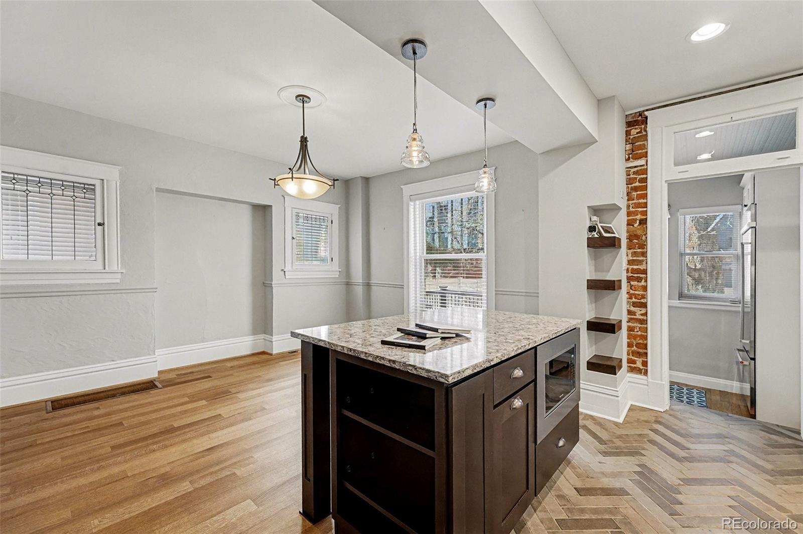 1419 Adams Street Denver, CO 80206 - Photo 14 of 34 a kitchen with kitchen island stainless steel appliances a sink stove and wooden floor