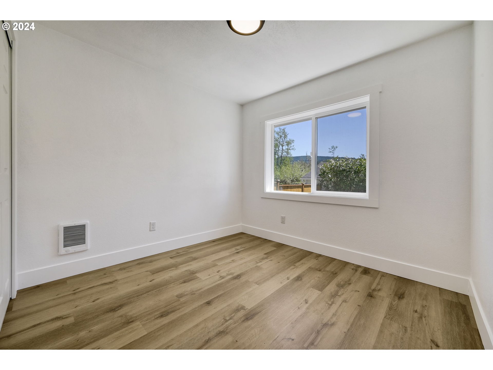 92045 Maple Lane Springfield, OR 97478 - Photo 9 of 21 a view of an empty room with wooden floor and a window