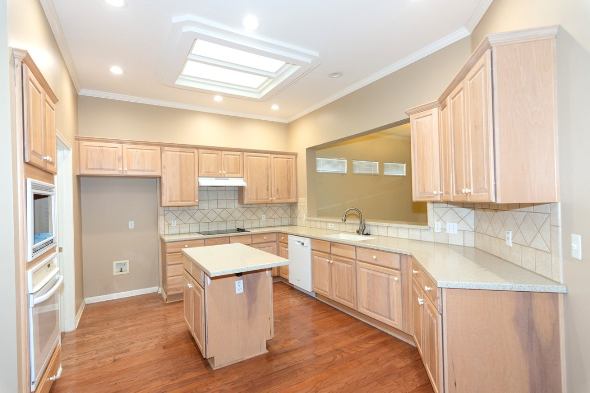 102 Harness Lane Georgetown, TX 78633 - Photo 15 of 32 Kitchen with light wood-type flooring, ornamental molding, light brown cabinets, and recessed lighting