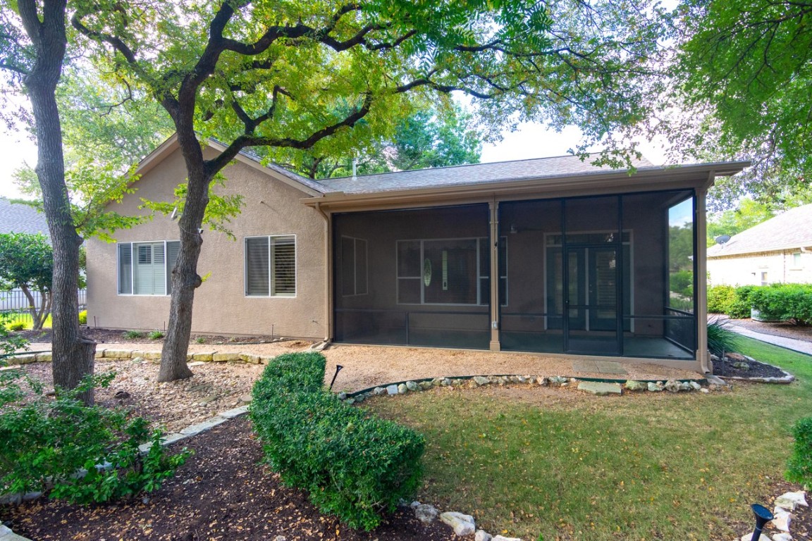 102 Harness Lane Georgetown, TX 78633 - Photo 29 of 32 Rear view of house featuring stucco siding, a yard, and a sunroom