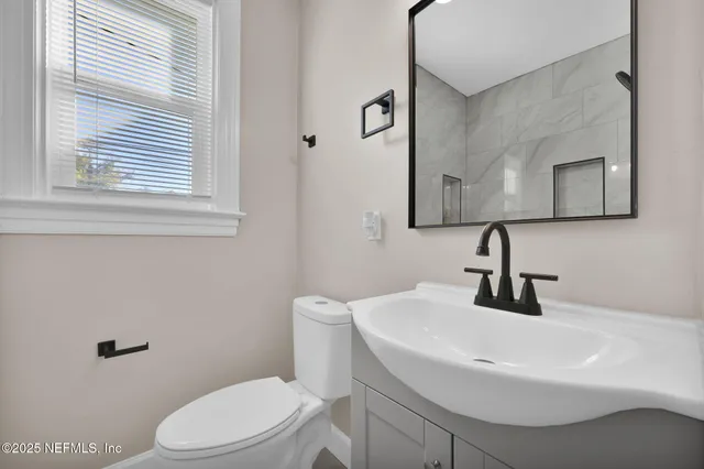 a bathroom with a sink a toilet and mirror
