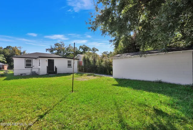 a view of a house with backyard and a tree
