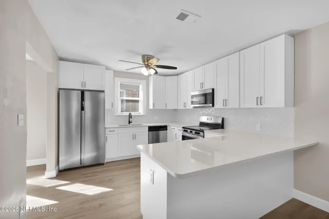 a kitchen with stainless steel appliances a refrigerator sink and microwave