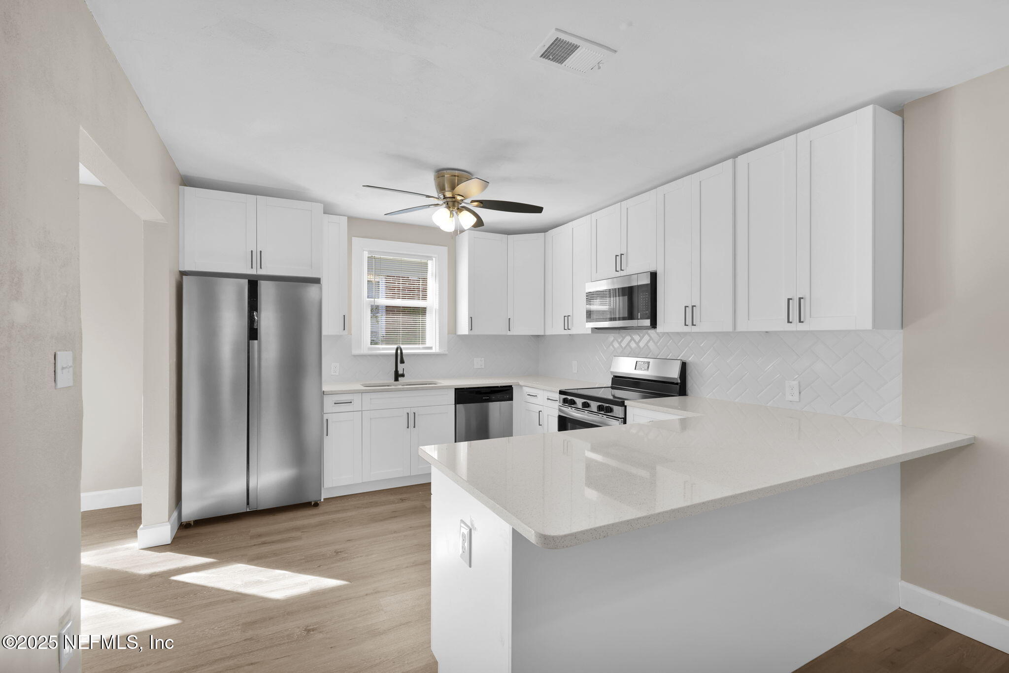 1157 West 10th Street Jacksonville, FL 32209 - Photo 10 of 23 a kitchen with stainless steel appliances a refrigerator sink and microwave