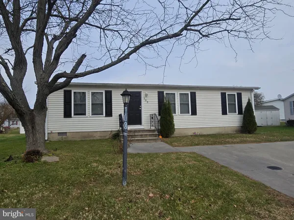 a view of a yard in front of a house with a large tree