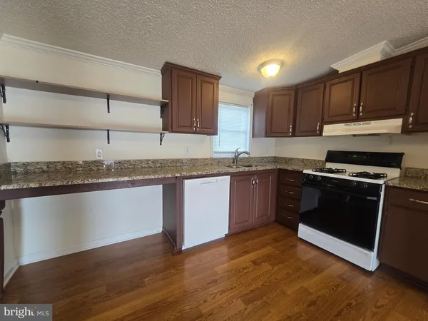 a kitchen with granite countertop wooden cabinets and a stainless steel appliances