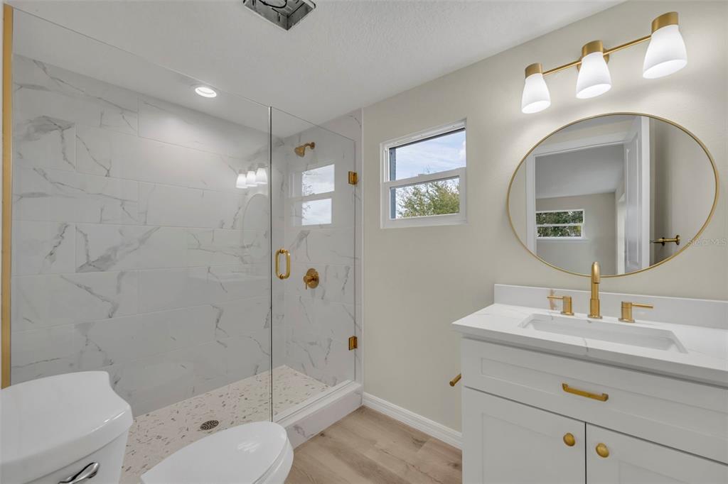 31201 Merry Road Tavares, FL 32778 - Photo 31 of 40 a bathroom with a toilet a sink and mirror
