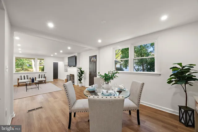 a living room with furniture a large window and stainless steel appliances