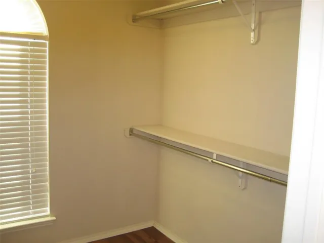 a view of a small space with wooden floor and a window