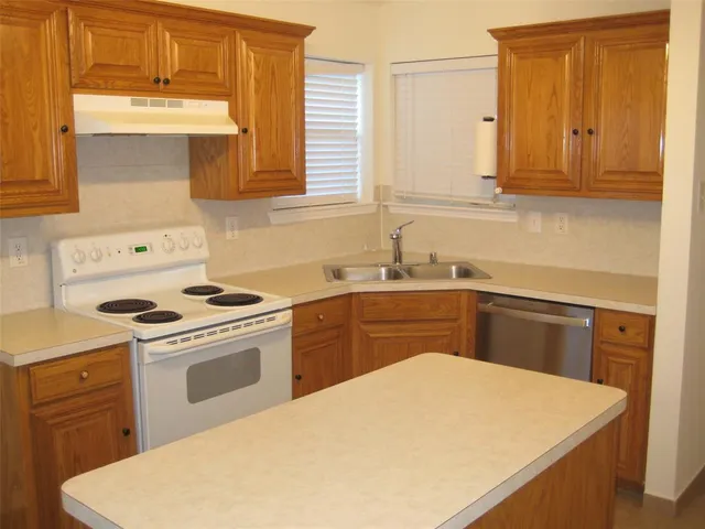 a kitchen with a sink stove and cabinets