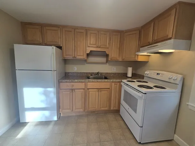a kitchen with a stove top oven cabinets and a refrigerator