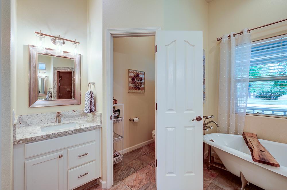 17465 Monreal Road Madera, CA 93636 - Photo 36 of 59 a bathroom with a granite countertop sink mirror and a