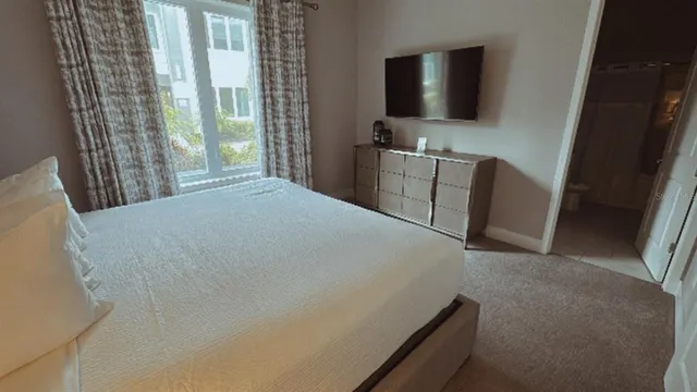 a bed sitting in a bedroom next to a window