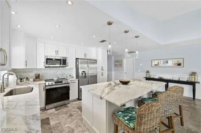 a large kitchen with stainless steel appliances kitchen island granite countertop a sink and cabinets