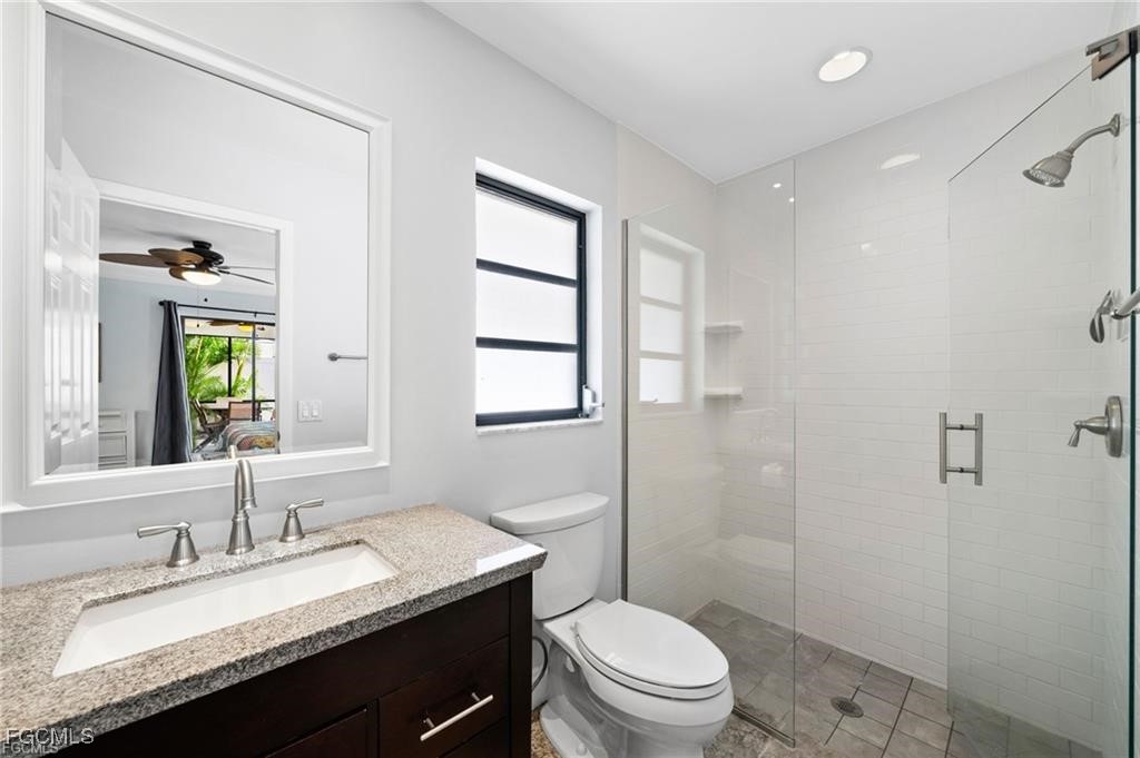 521 102nd Avenue North Naples, FL 34108 - Photo 19 of 25 a bathroom with a granite countertop sink toilet a mirror and shower