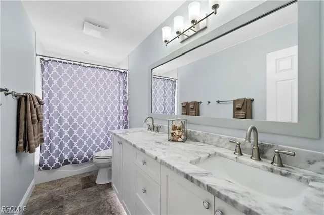 a bathroom with a granite countertop double vanity sink mirror and shower