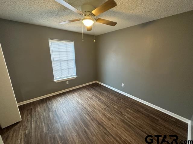3807 McDonald Road Tyler, TX 75701 - Photo 8 of 10 an empty room with wooden floor chandelier fan and windows