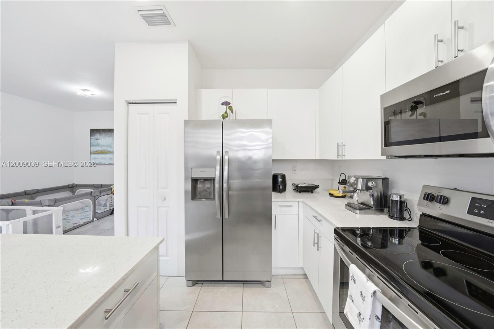24644 Southwest 118 Court Homestead, FL 33032 - Photo 12 of 33 a kitchen with stainless steel appliances granite countertop a stove a refrigerator and a sink