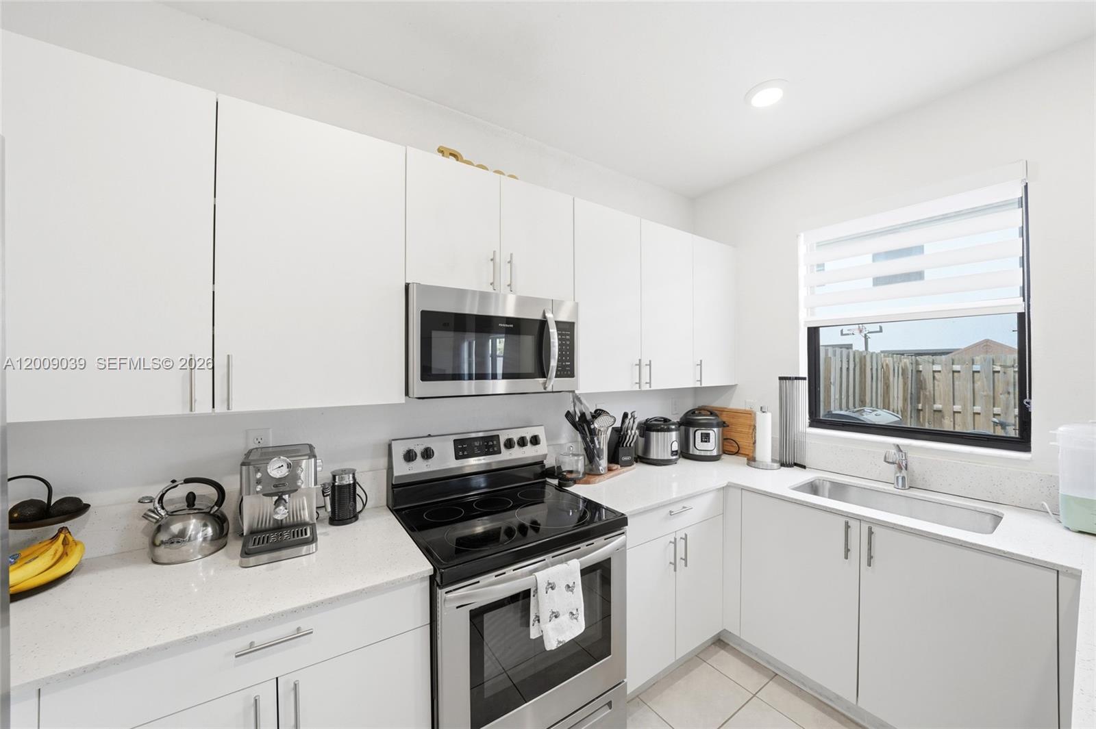 24644 Southwest 118 Court Homestead, FL 33032 - Photo 9 of 33 a kitchen with stainless steel appliances a sink a stove and a microwave