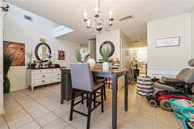 a living room with furniture a clock and a view of kitchen
