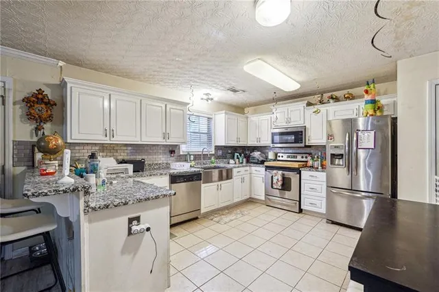 a kitchen with granite countertop appliances cabinets and a counter space
