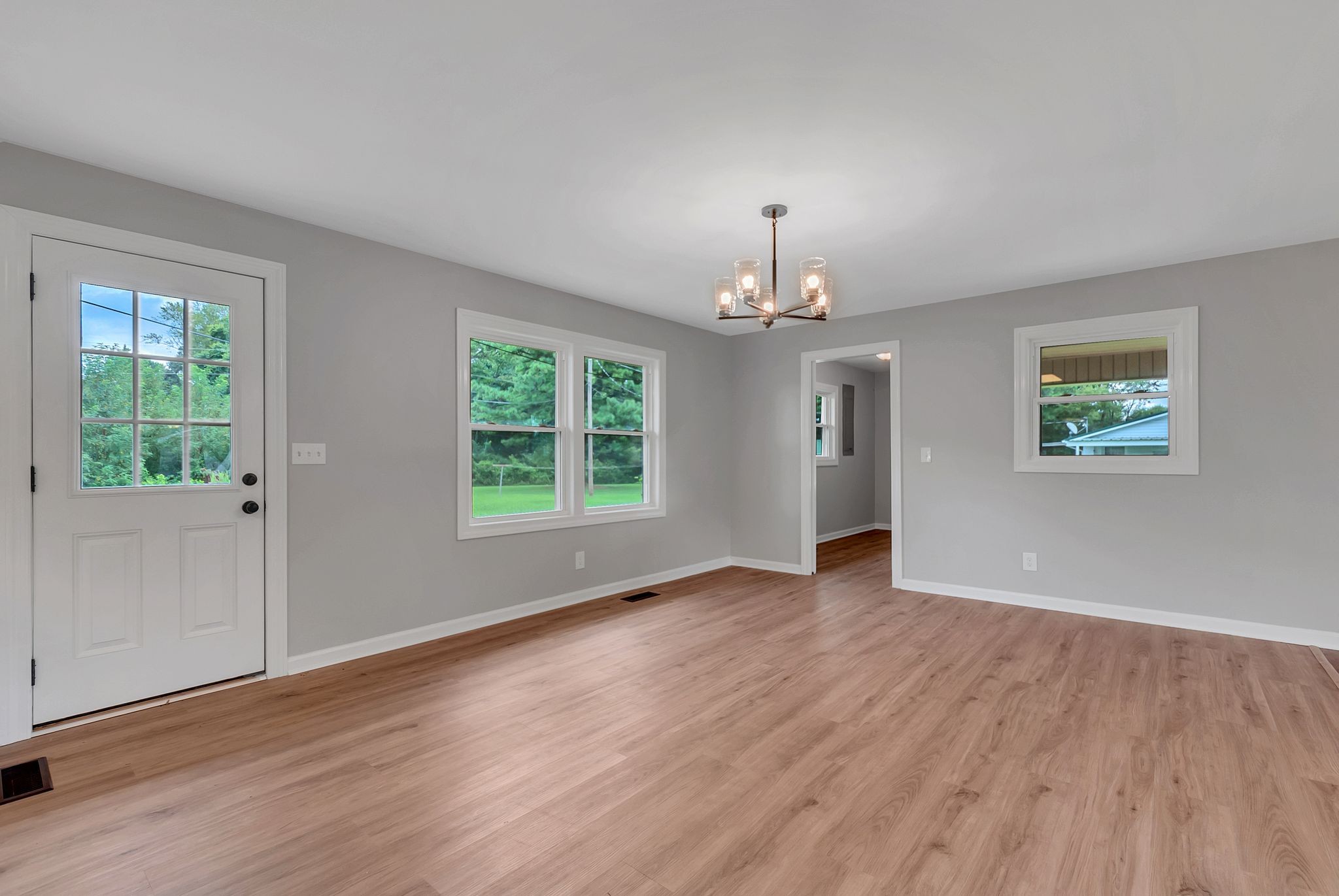 107 Horseshoe Bend Road Leoma, TN 38468 - Photo 12 of 35 an empty room with wooden floor chandelier and windows
