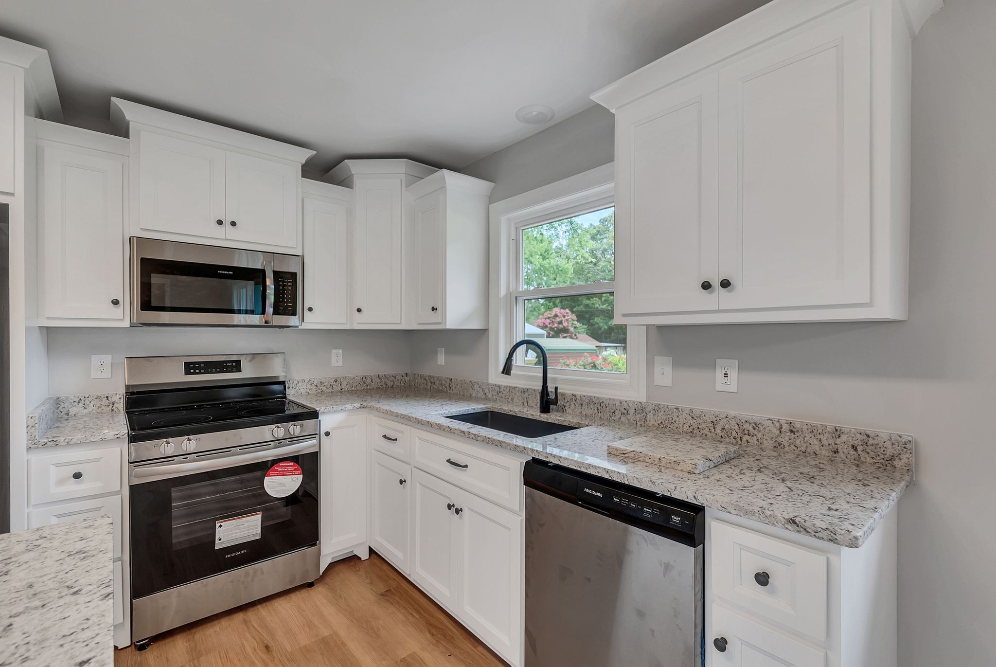 107 Horseshoe Bend Road Leoma, TN 38468 - Photo 18 of 35 a kitchen with granite countertop white cabinets white stainless steel appliances and a sink