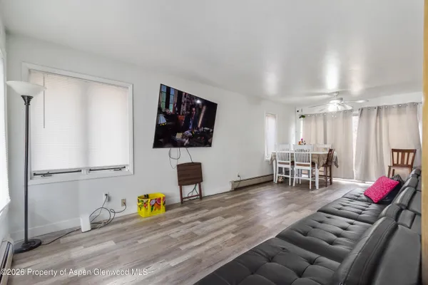 a living room with furniture a flat screen tv and lawn chairs