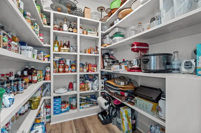 a bedroom with a bed and a lamp on dresser