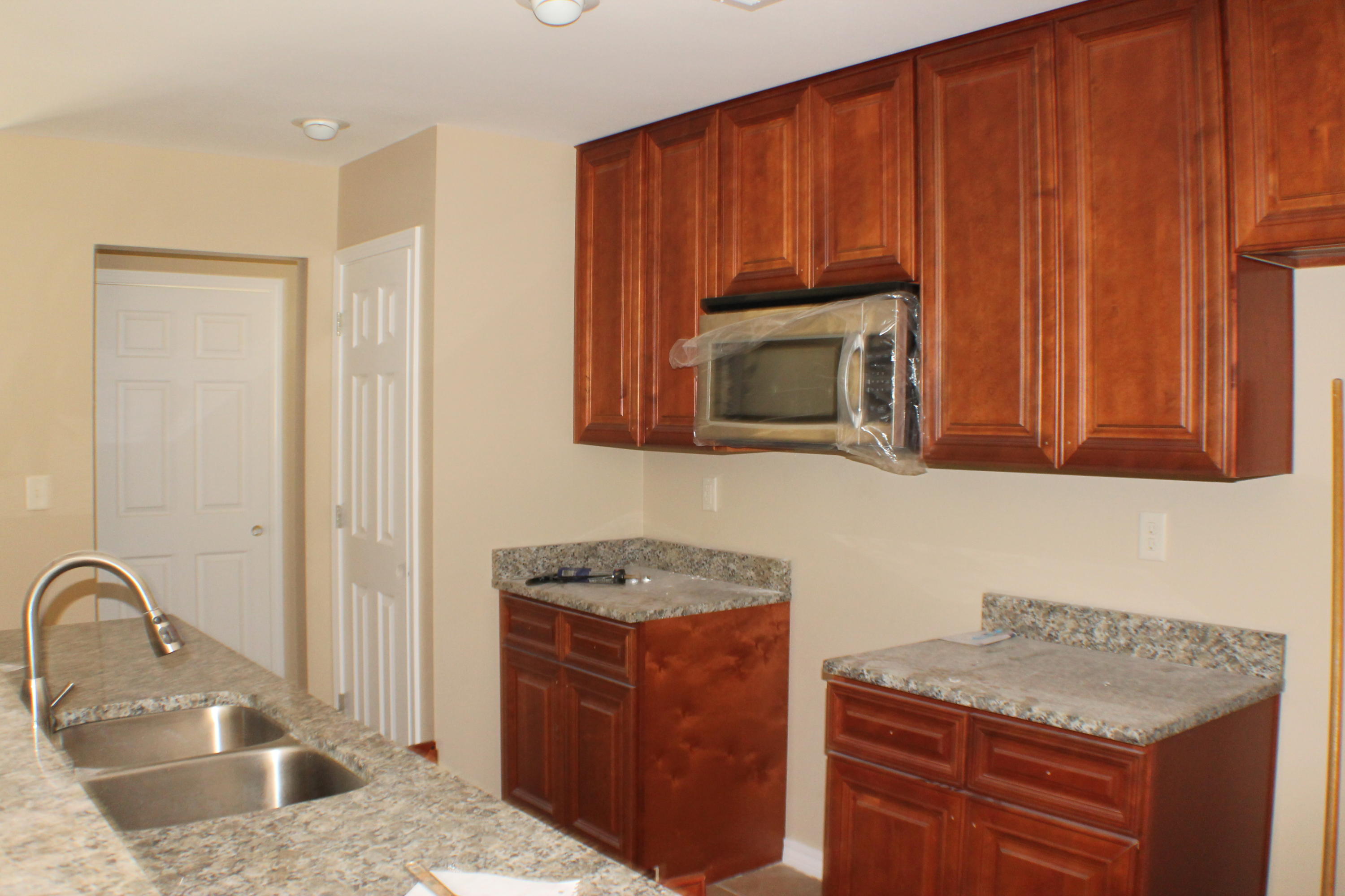 5588 Old Bethel Road Crestview, FL 32536 - Photo 15 of 42 a kitchen with granite countertop wooden cabinets a stove and a sink