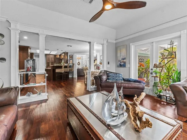 a kitchen with stainless steel appliances kitchen island granite countertop a table chairs cabinets and wooden floor