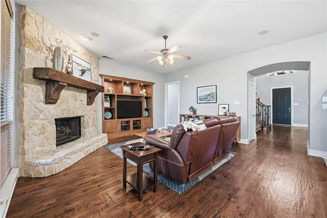 a living room with furniture a flat screen tv and a fireplace