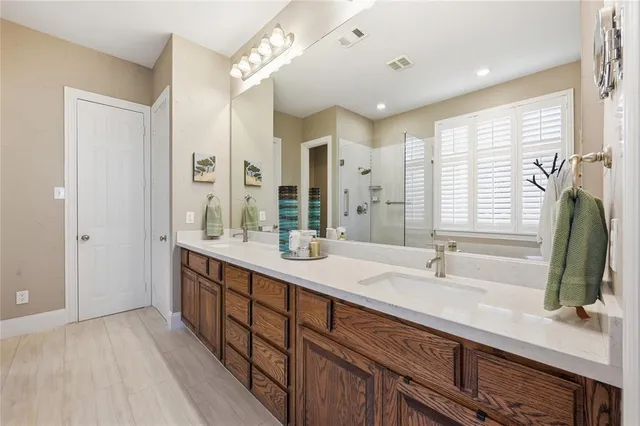 a bathroom with double vanity sinks double vanity and a large mirror