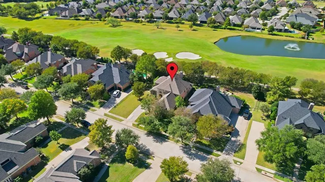an aerial view of a house with a garden and lake view