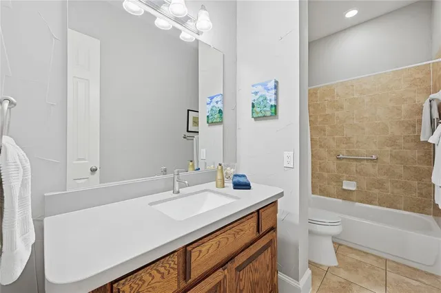 a bathroom with a granite countertop sink a toilet a shower and a mirror