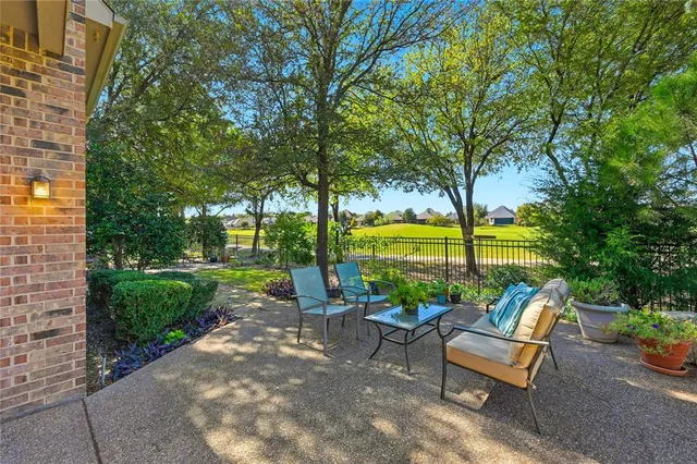 a view of a patio with couches and table and chairs with wooden fence and floor
