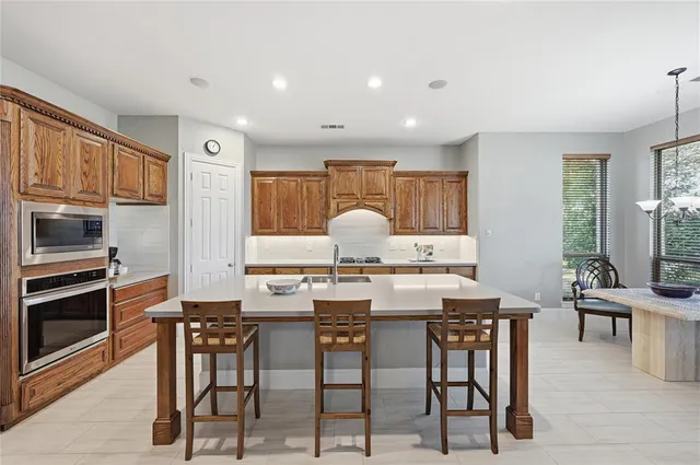 a kitchen with granite countertop a table chairs stove and cabinets